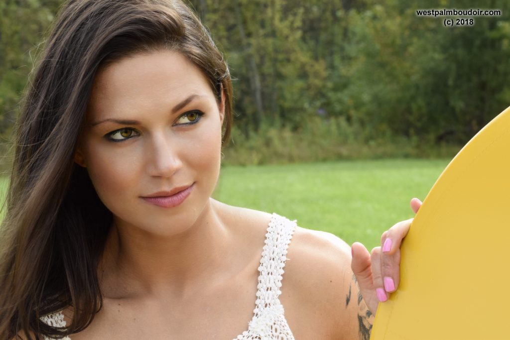 Brunette woman glamour portrait in white dress with airplane