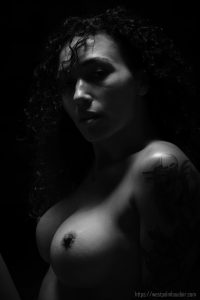 topless woman in black and white looking at camera